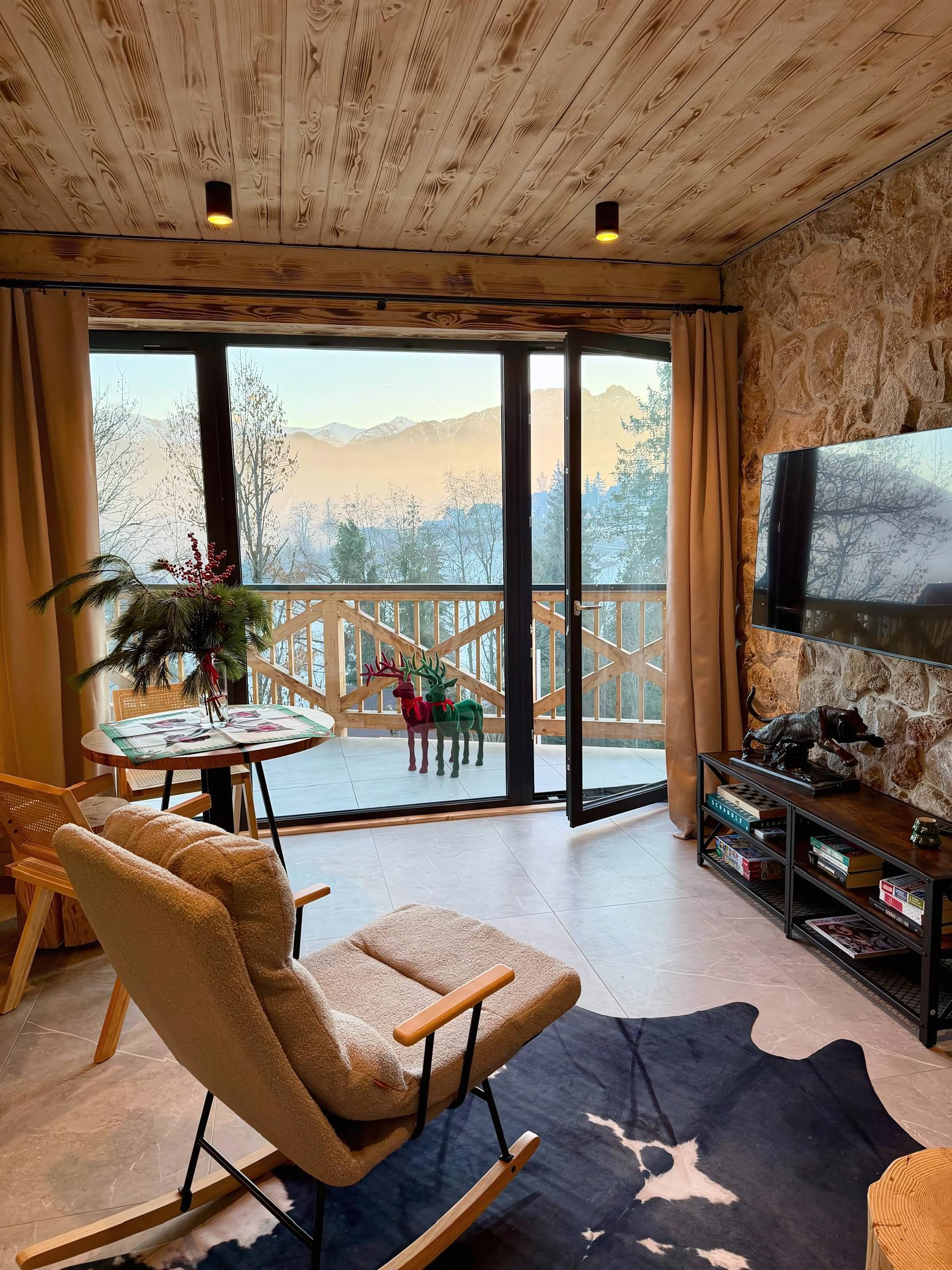 Bujany fotel w salonie, za oknem Tatry o świcie